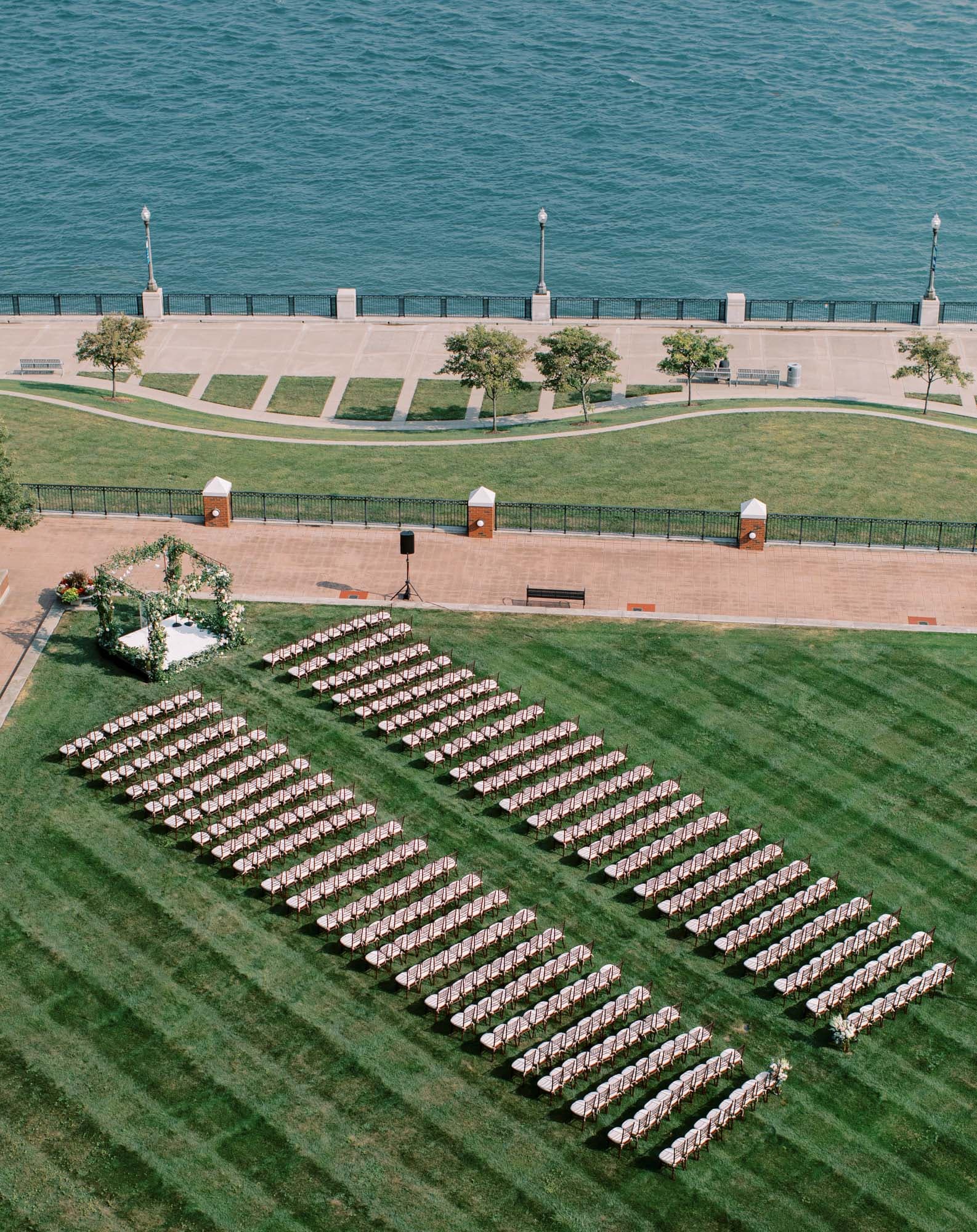 Riverfront garden of The Icon set with theater style chairs for a ceremony with the Detroit river in the background.
