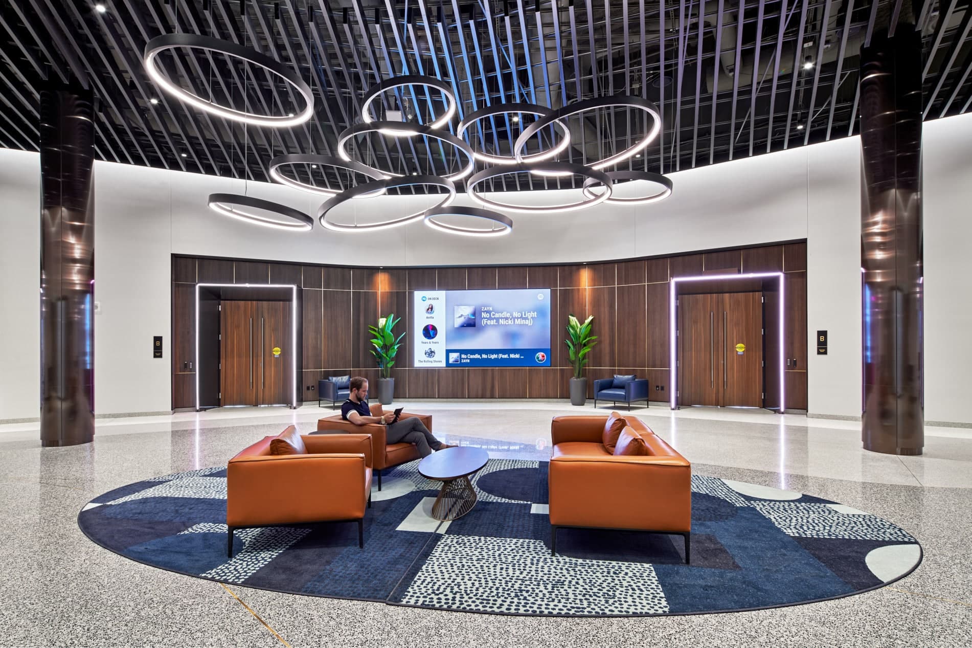 Pre-function lobby space of Elevate at One Campus Martius set with furniture grouping under large circular chandelier in the center of the room.